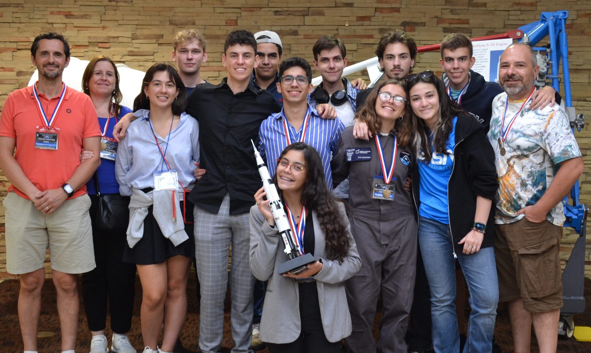 Students and mentors with medals and a rocket trophy at ISSDC 2023